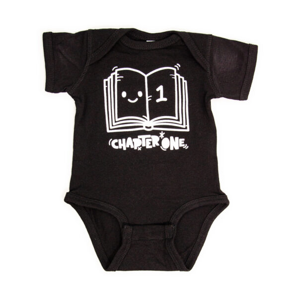 A black heather onesie with a drawing of a book and chapter one written below